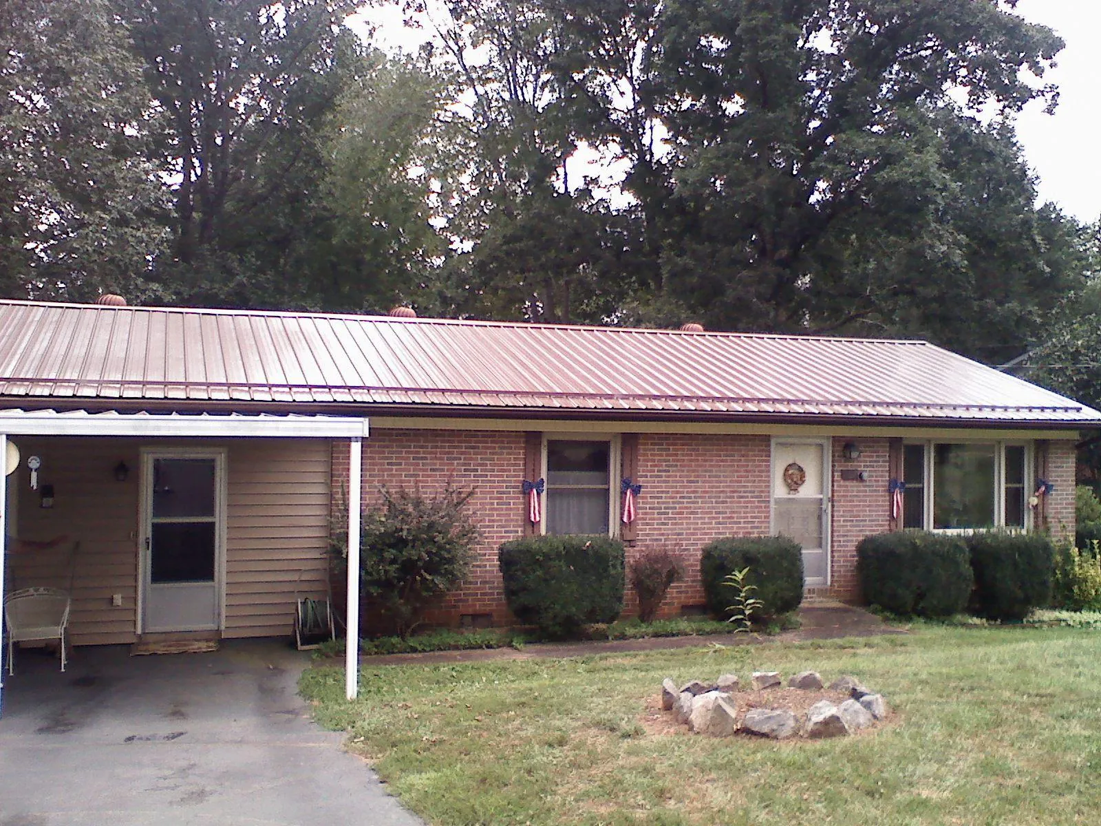 Bronze metal roof and carport on a brick ranch home — Roof Repair work by our crew in Leslie